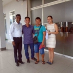 three mens and one women standing infront of glass door